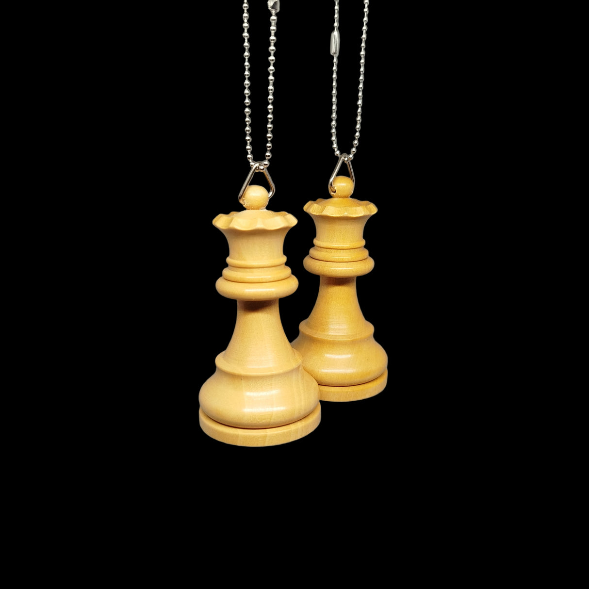 Two wooden chess piece pendants hanging from chains